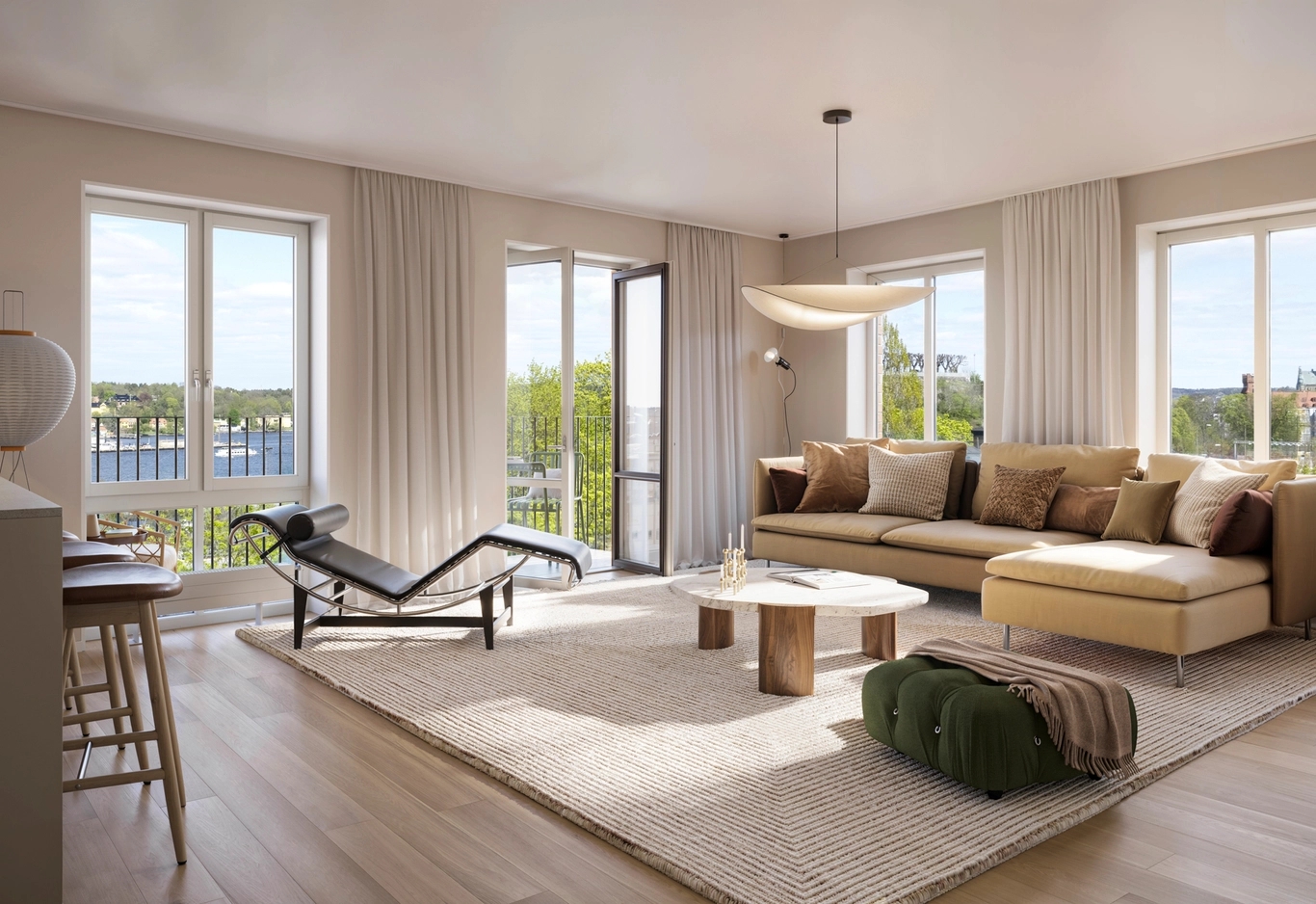Vardagsrum med soffgrupp och utsikt mot vattnet från balkongen i bakgrunden