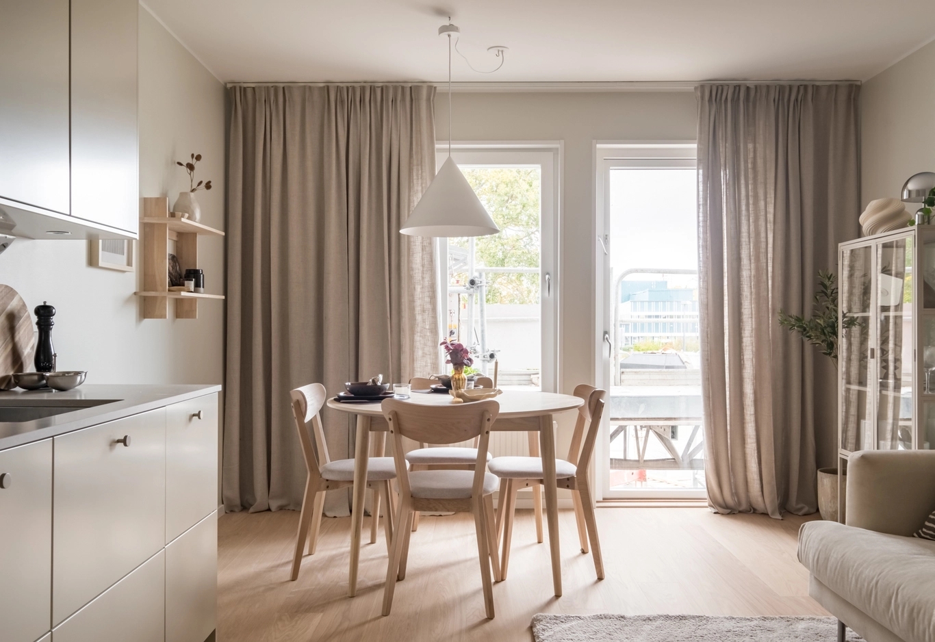Matplats i anslutning till fönsterparti med långa gardiner.