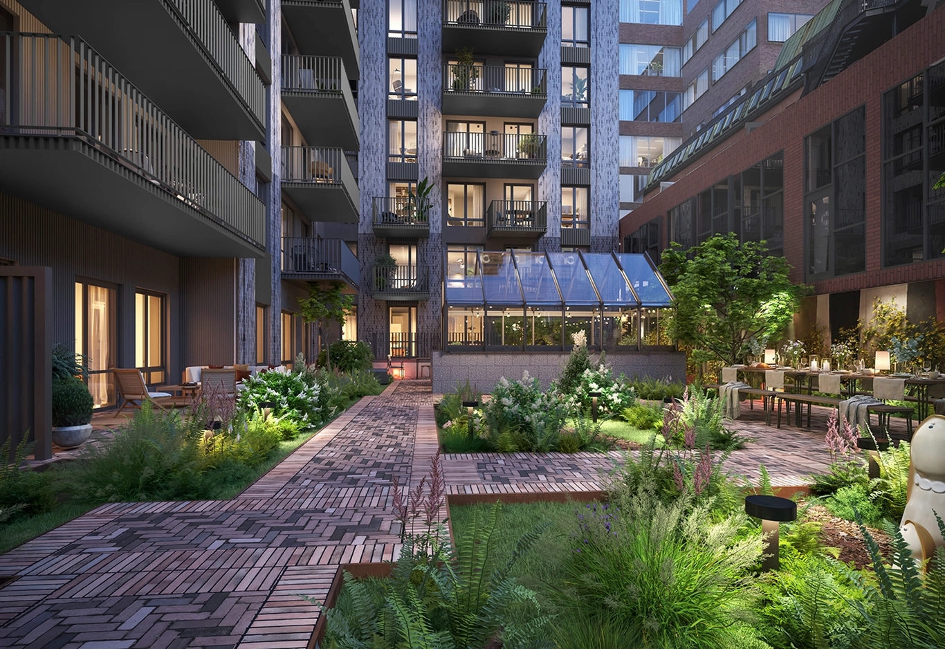 Gård med växthus framför ett flerfamiljshus i tegel,