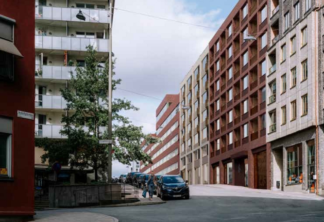 Ett bostadshus klätt i tegelfasad syns längs med en trafikerad stadsgata.